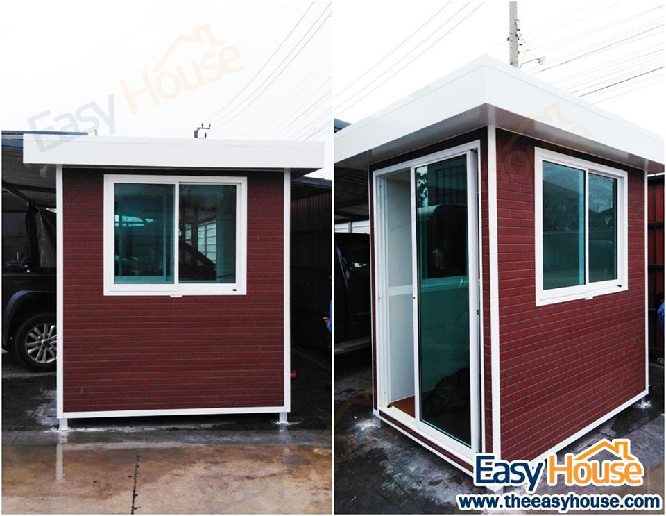 ป้อมยามสำเร็จรูป GB03 สีขาวตัดน้ำตาล มุมมองด้านข้างแสดงหน้าต่างกระจกและประตูทางเข้า ตั้งอยู่บนพื้นปูนกลางแจ้ง