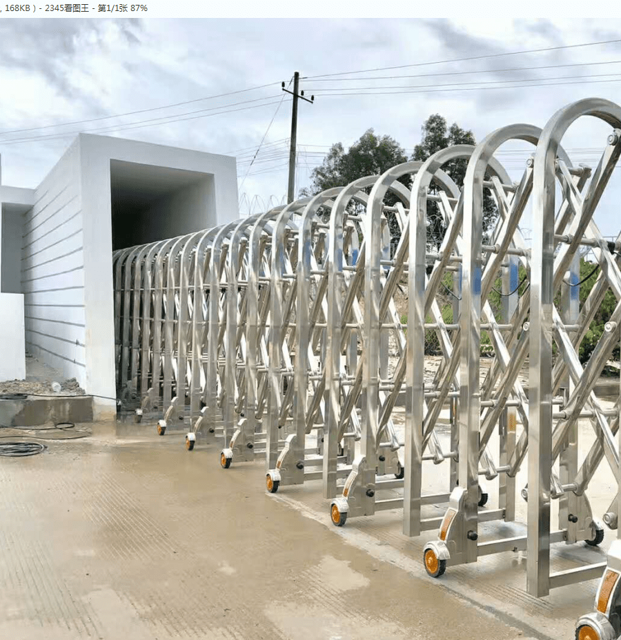 ประตูโฟลดิ้งเกท Folding Gate สีเงินสแตนเลสแบบพับได้ ติดตั้งบนพื้นเรียบ มุมมองด้านข้างแสดงโครงสร้างเหล็กซิกแซกแข็งแรง
