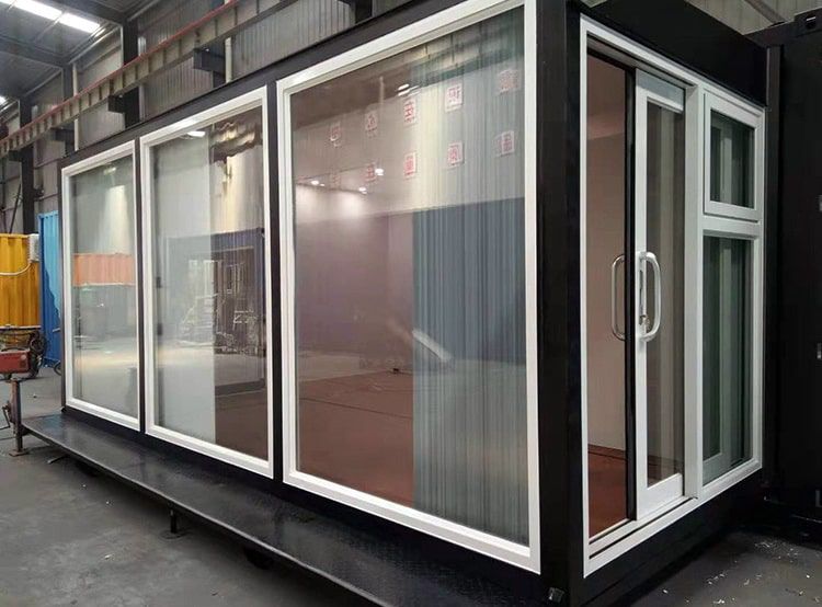 ออฟฟิศสำเร็จรูป TEH-CH08 สำนักงานผนังกระจกขนาด 6x3 เมตร สีขาวดีไซน์ทันสมัย ตั้งอยู่ริมสระว่ายน้ำในบรรยากาศสวนกลางแจ้ง มุมมองเฉียงด้านข้าง