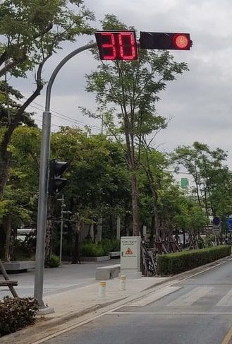 เสาไฟฟ้า Mast arm โค้ง สีเทาเข้ม ดีไซน์แขนยื่นแนวนอน ติดตั้งบนฐานรองรับเหล็กแข็งแรงสำหรับงานระบบไฟฟ้าและแสงสว่าง