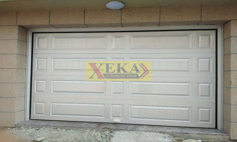 ประตู Overhead Sectional door รุ่น OHD-13 สีขาว มีช่องกระจกสี่เหลี่ยม ติดตั้งแบบยึดเพดานสำหรับโรงงานหรือโกดังสินค้า