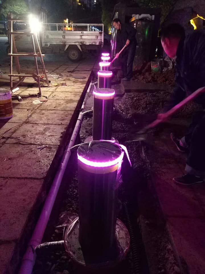 เสากั้นถนน Bollard รุ่น BL-HD01 วัสดุสแตนเลสสีเงินเงางาม มีแถบสีเหลืองสะท้อนแสง ติดตั้งแบบฝังพื้นบนฐานวงกลม มุมมองด้านหน้าตรง