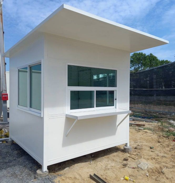 ป้อมยามสำเร็จรูป Guard Booth GB11 สีขาว ดีไซน์ทันสมัย ขนาด 2.0x2.0 ม. มุมมองเฉียงเห็นหน้าต่างกระจกใสรอบด้านบนพื้นราบ