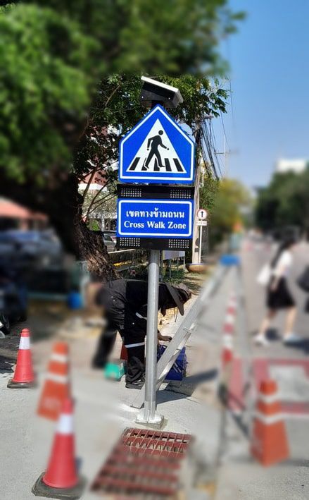 ป้ายเขตทางข้ามถนนสีน้ำเงินทรงสามเหลี่ยมพร้อมแผงโซลาร์เซลล์ติดตั้งบนเสาสีเงินตั้งตรงสำหรับใช้งานกลางแจ้ง