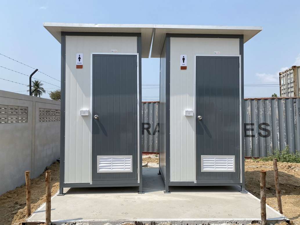 ห้องน้ำสำเร็จรูป ตู้เดี่ยว Muji Toilet สีขาวตัดขอบเขียว ดีไซน์มินิมอลแบบตู้เดี่ยว ตั้งวางบนขาตั้งเหล็กในมุมมองเฉียงด้านข้าง
