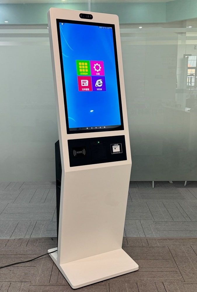 ตู้ Self Service Kiosk รุ่น KDS-010 สีขาว ดีไซน์ทรงสูงแบบตั้งพื้น มุมมองด้านข้างและด้านหน้า แสดงหน้าจอและช่องสแกนเนอร์