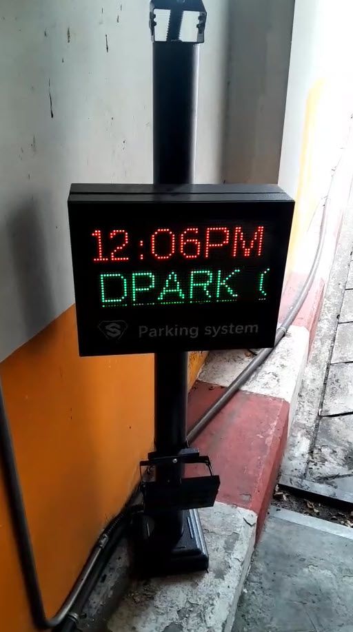 ป้ายแสดงผลลานจอดรถ Matrix Display P4.75 แสดงข้อความสีแดงและเขียวบนหน้าจอสีดำ ติดตั้งบนเสาสีเทาในมุมมองด้านหน้าตรง